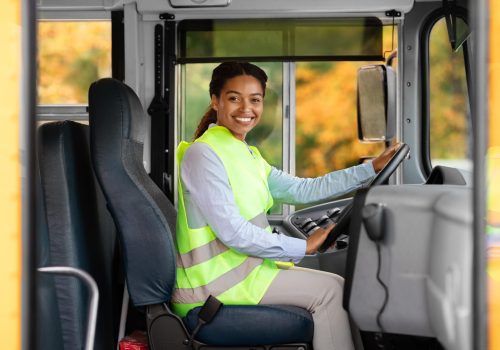 happy-black-female-driver-sitting-in-bus-and-looki-2025-03-18-16-17-22-utc-min